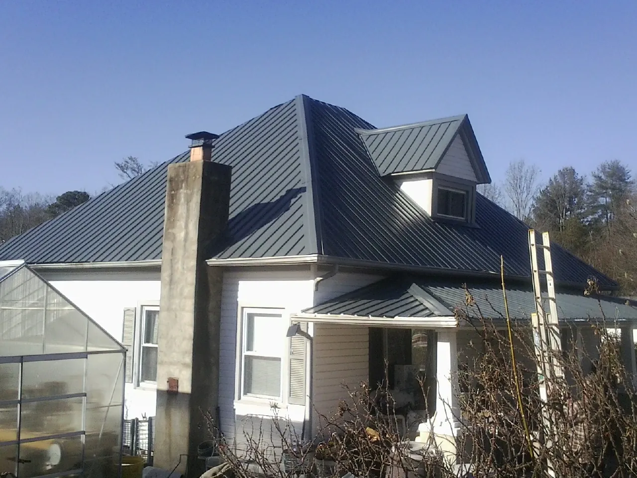 Dark blue standing seam metal roof on a white farmhouse with dormer — Slate & Tile Roof Repair by Roofing Brothers in Nashport