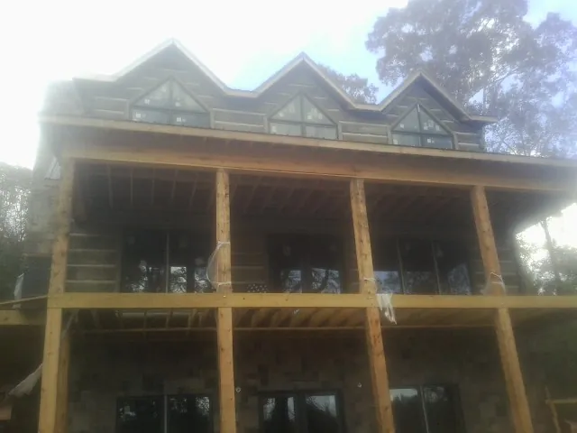 Dormers and porch framing on a large log home under construction — Roof Coating work by our crew in Nashport