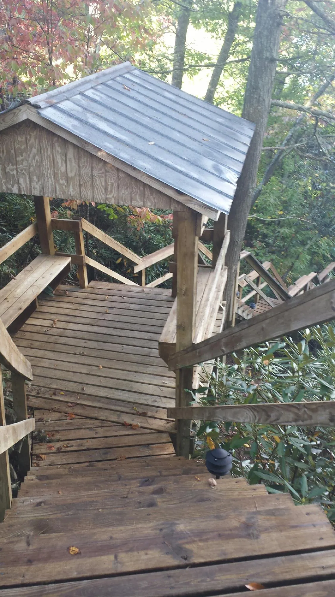 Metal roofed shelter over wooden steps on a wooded walkway — Skylight Repair & Installation work by our crew in Nashport