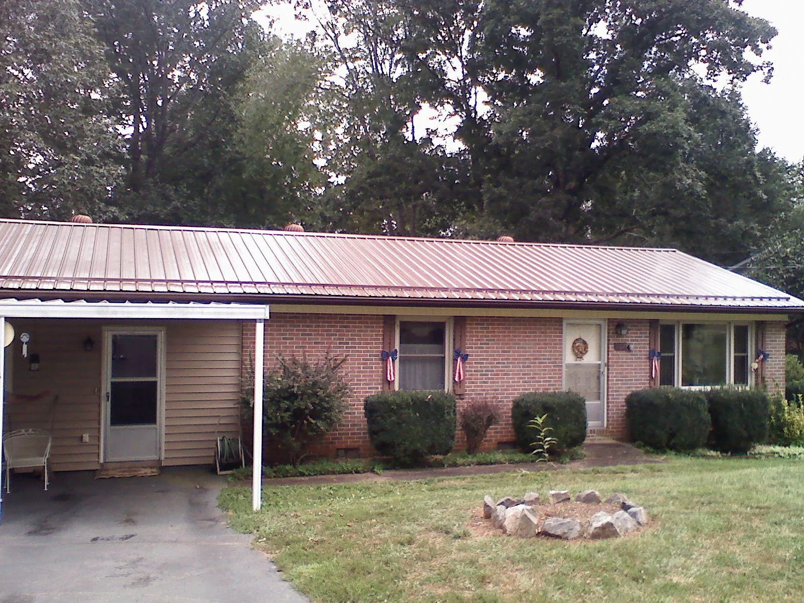 Bronze metal roof and carport on a brick ranch home — Roof Repair work by our crew in Nashport
